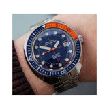 "Persona enseñando detalles del fondo del reloj color azul y naranja"